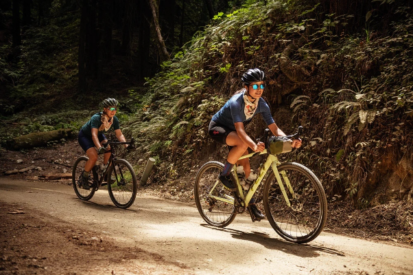 Two bicyclists exercise riding their bikes.