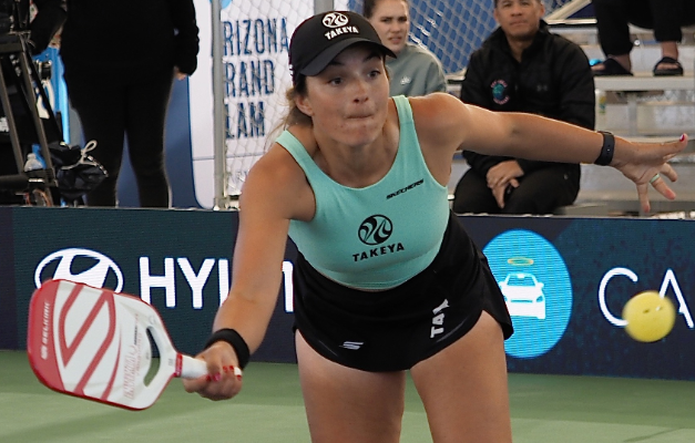woman hitting a pickleball with a paddle