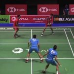 Badminton match played on court while a player dives