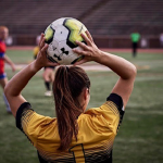 Woman soccer player throwing a ball