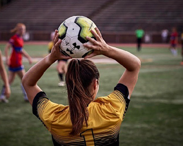 Woman soccer player throwing a ball
